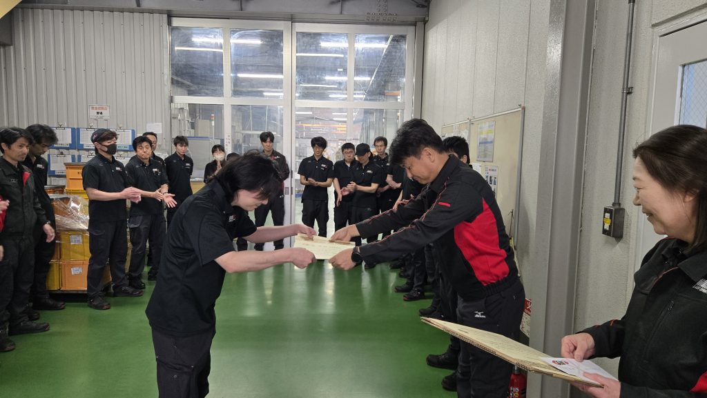 製造社員Aがばね検定合格の表彰を受けている