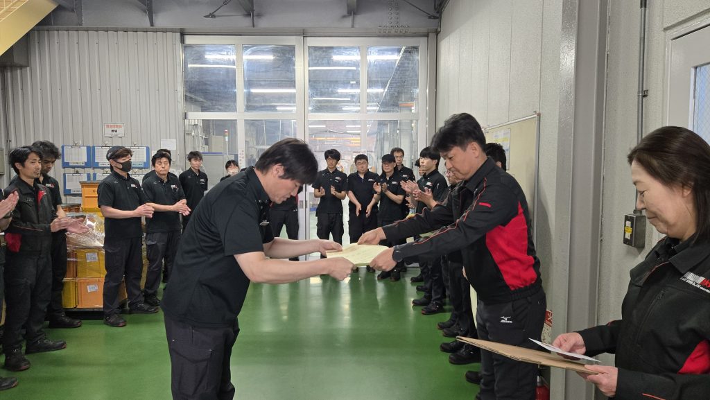 製造社員Yがばね検定合格の表彰を受けている