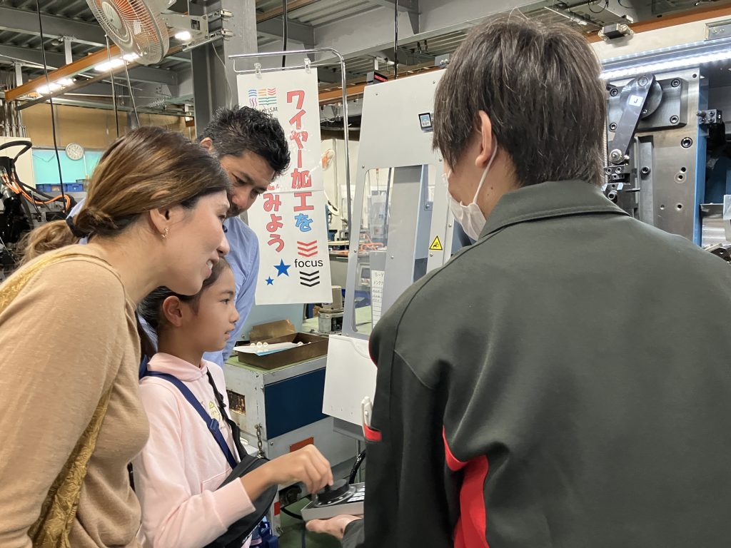 できる製品を見つめながら機械を操作する親子