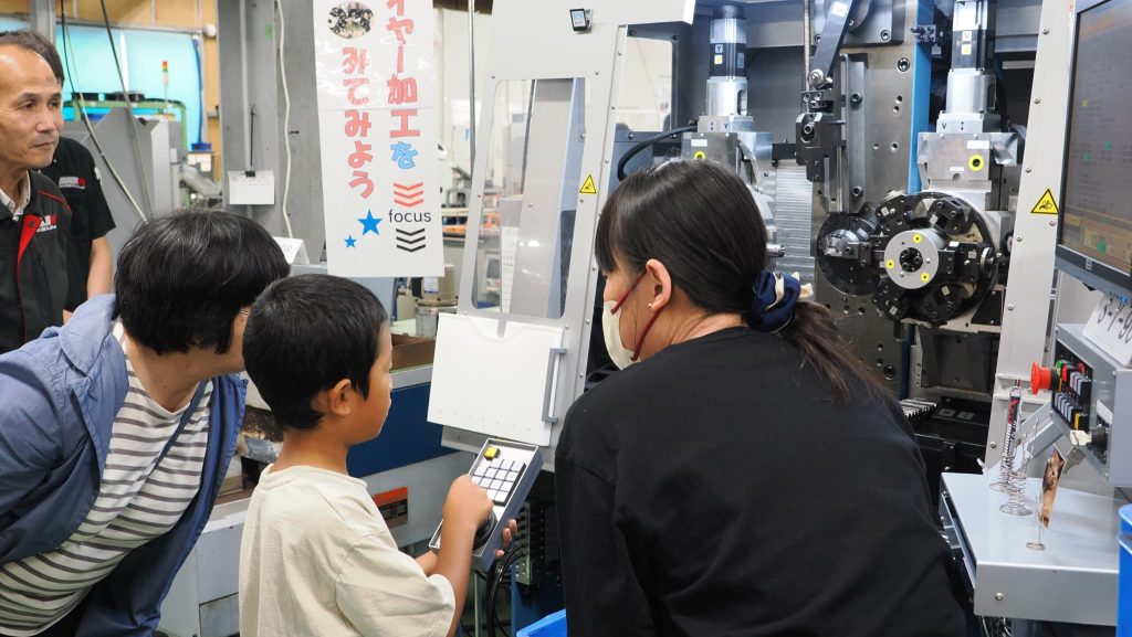 ワイヤーフォーミングマシンのハンドルを回す男の子