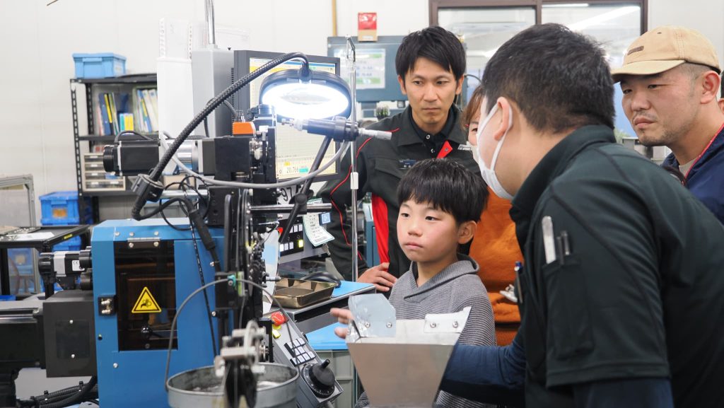 コイリングマシンの説明を受ける男の子