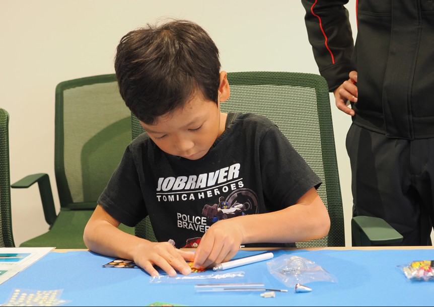 ボールペンにフィルムを巻き付ける男の子